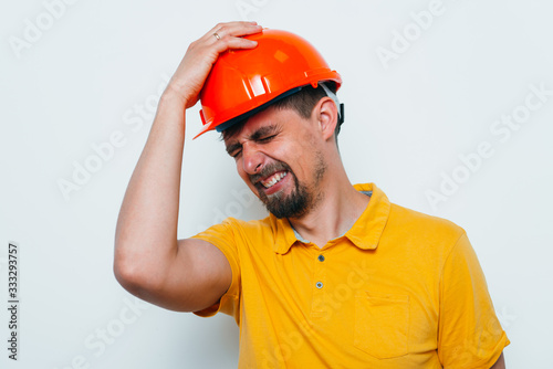 man close-up in helmet , holding his head by hand
