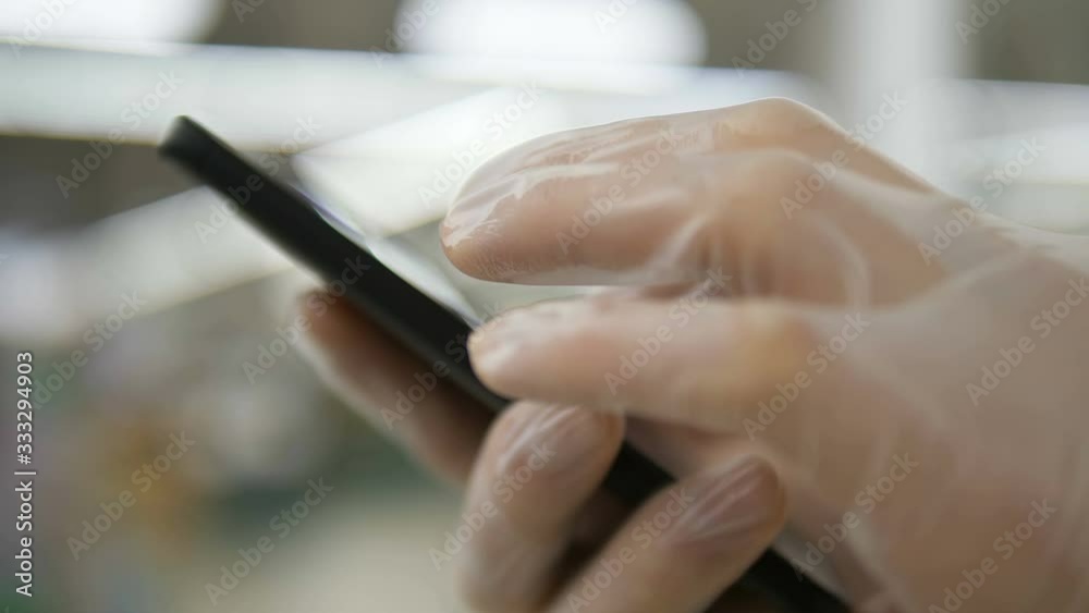close-up of man imedical gloves uses smartphone close-up of man imedical gloves uses smartphone