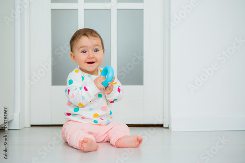 Toddler girl plays educational games at home. Baby sits on the floor of the house