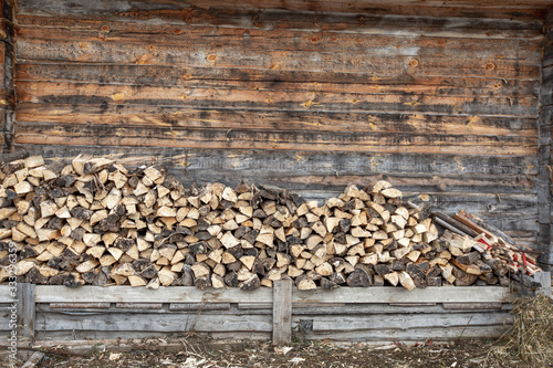 Firewood storage near the wall of village building photo