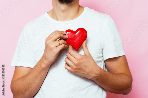 Portrait of a young man holding a large heart