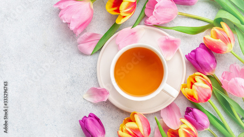 A cup of tea with tulips on white background