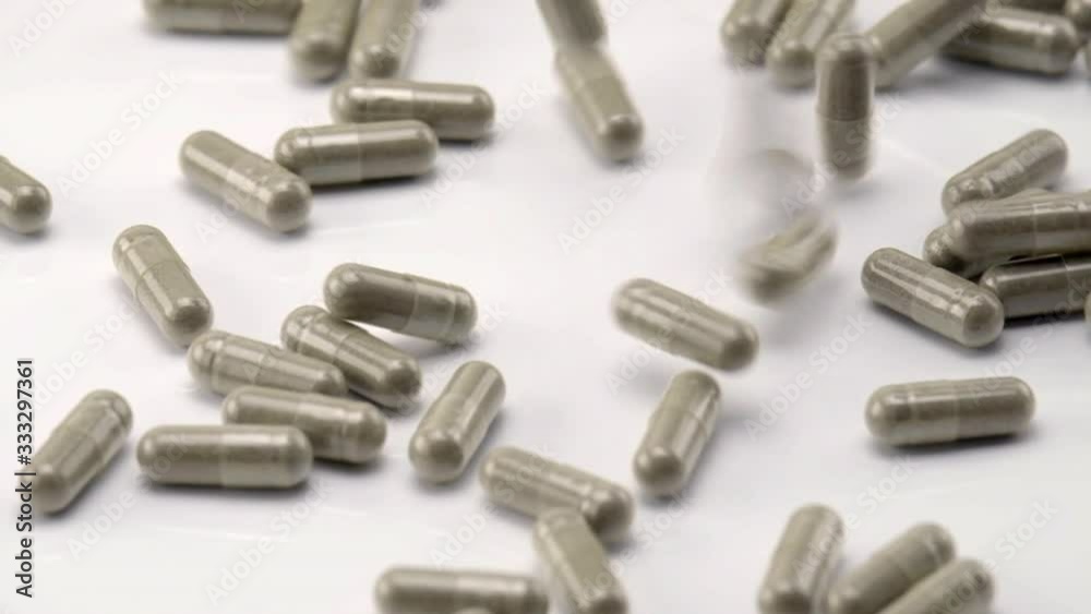 Close Up View of Natural Herbs Capsules Falling and Bouncing on White Background. Close Up View of Natural Herbs Capsules Falling and Bouncing on White Background.