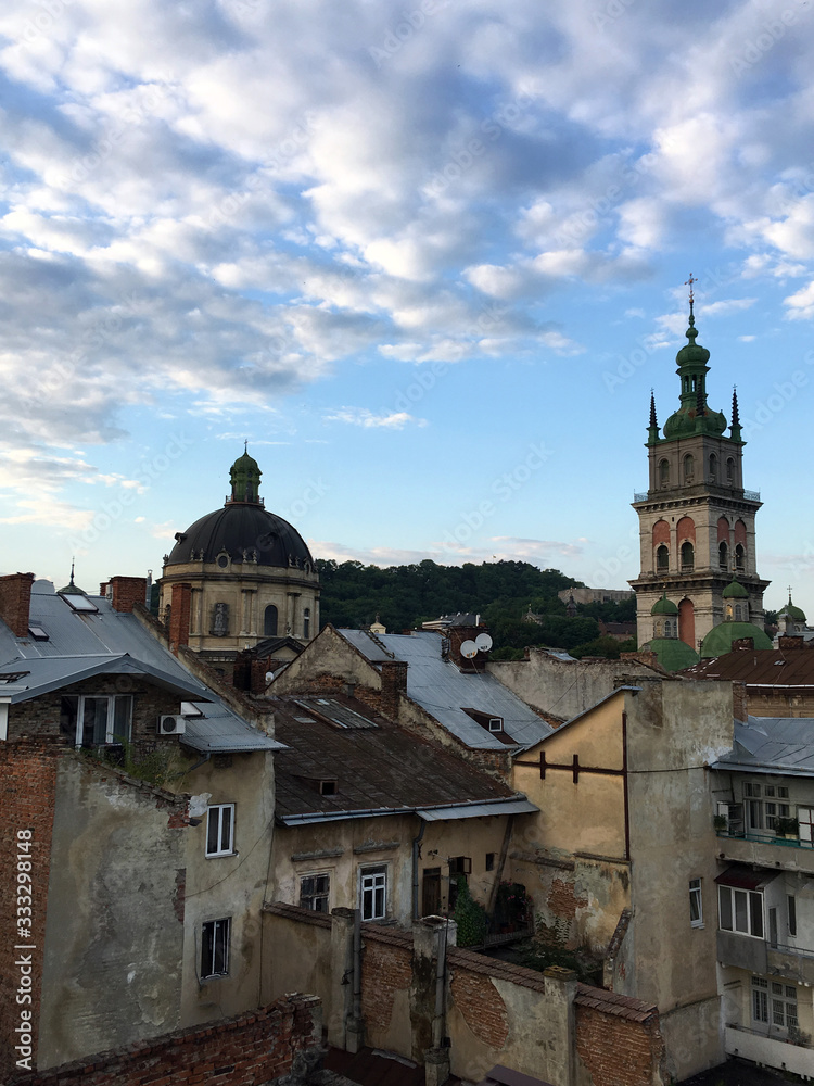 Fototapeta premium Sunset in Lviv, Ukraine. Ancient European architecture. Red colors. Against the background of the church