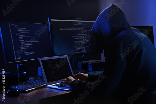 Hacker with computers in dark room. Cyber crime