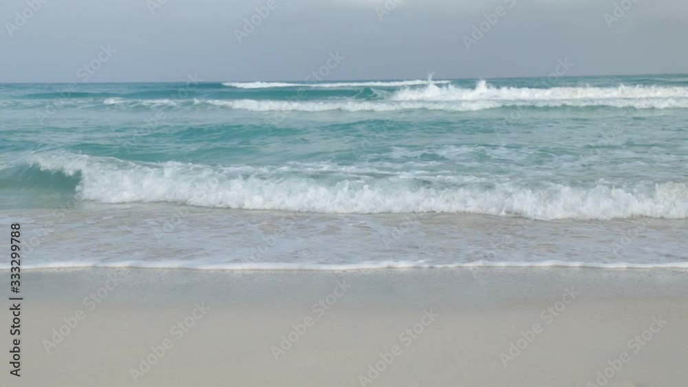 ocean waves on a sandy beach at summer day in tropical island