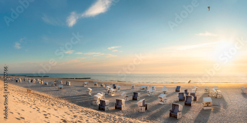 Beach scenery at sunset at North Sea. Beach chairs at Red Cliff, Sylt island. photo