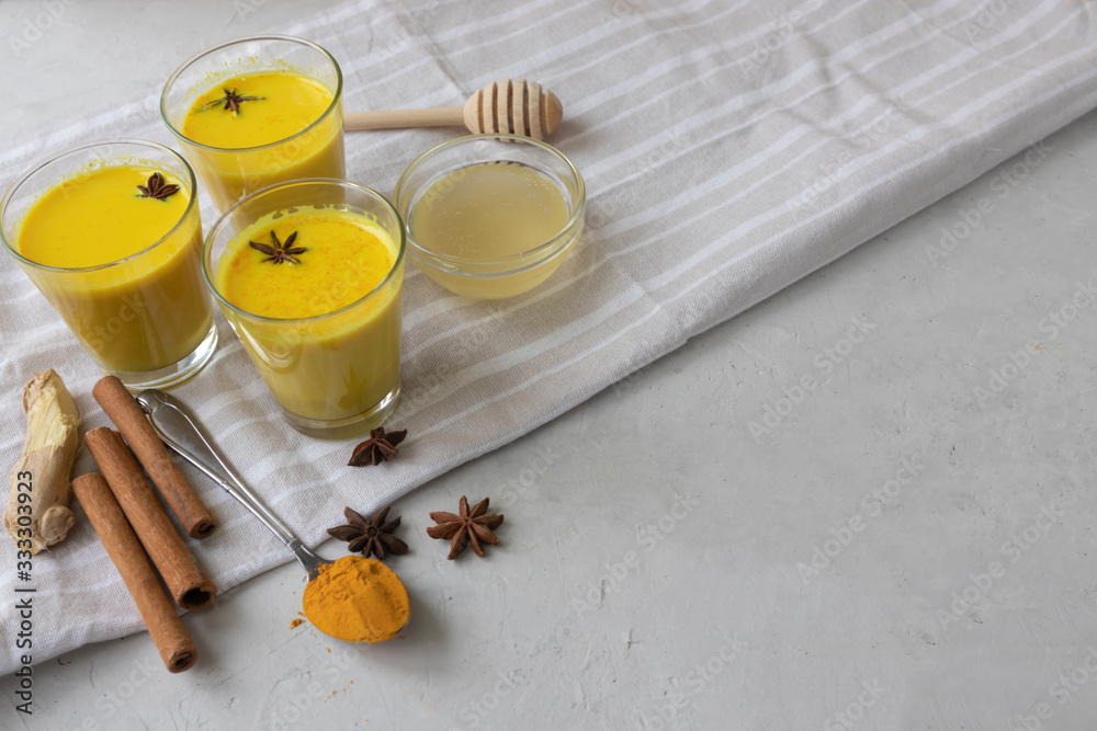 virus control, alternative medicine, Three glass cups with golden milk with turmeric and honey virus control, alternative medicine, Three glass cups with golden milk with turmeric and honey