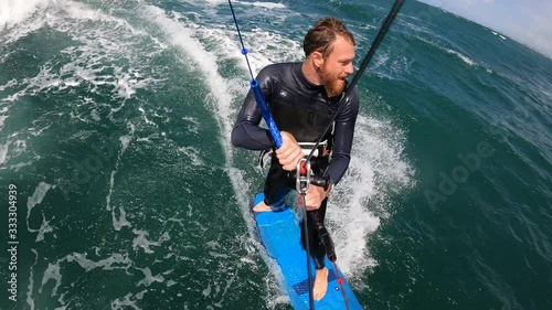 bearded man kitesurfing strapless in the waves