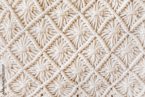 Close-up of hand made macrame texture pattern. ECO friendly modern knitting DIY natural decoration concept. Flat lay. photo