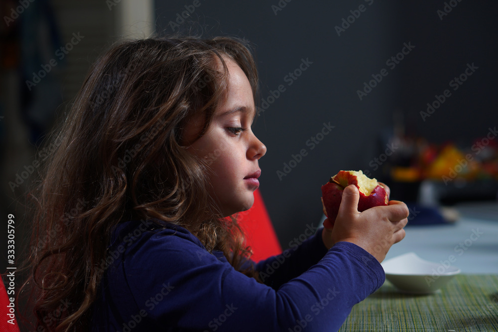 Pretty little girl with big eyes eats a red apple Pretty little girl with big eyes eats a red apple