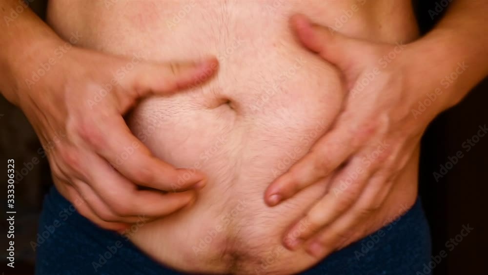 Man showing his fat on the stomach. Man showing his fat on the stomach.