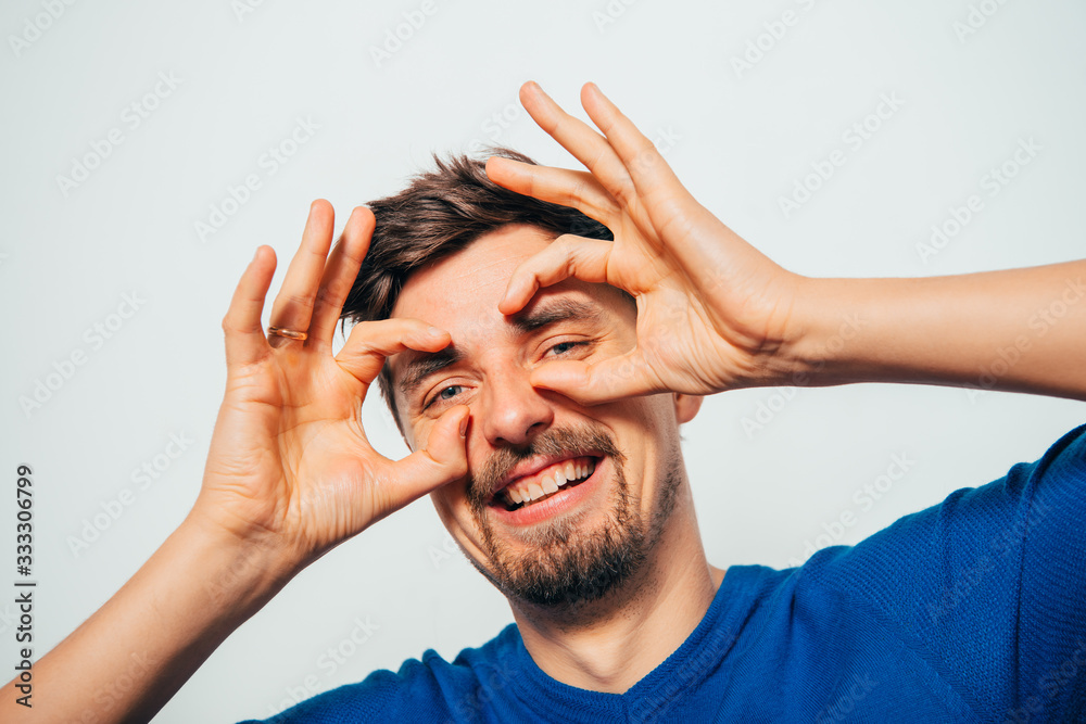 man looking through hands, making binoculars man looking through hands, making binoculars