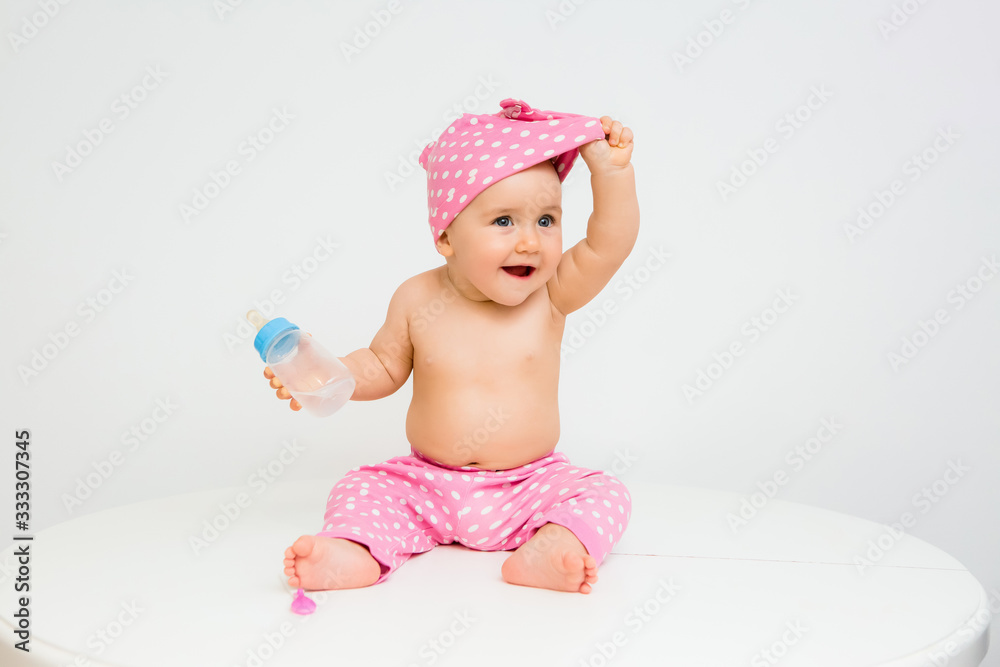 Healthy baby girl smiles and holds a water bottle Healthy baby girl smiles and holds a water bottle