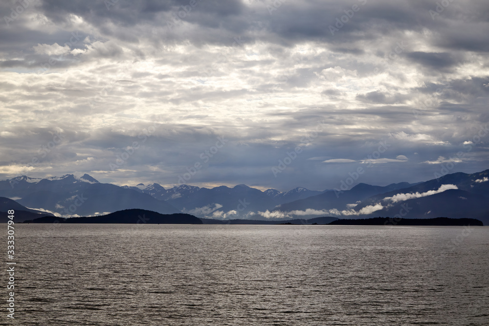 Beautiful early morning view of the mountains near Juneau, Alaska. Calm waters in the foreground 