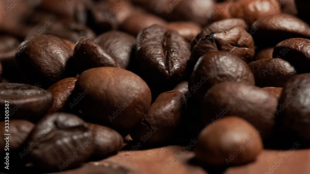 Naklejka premium Closeup of Roasted brown coffee beans lye on the table, front view.