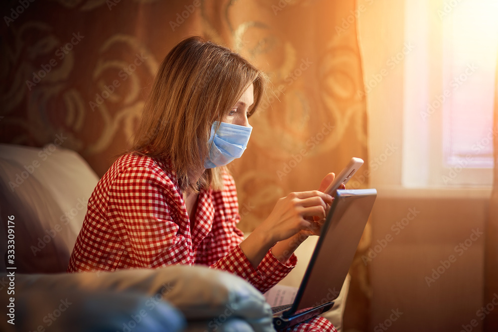 Young european woman wearing surgical face mask stay at home during coronavirus, covid-19 outbreak and looking news or application on smartphone. Young european woman wearing surgical face mask stay at home during coronavirus, covid-19 outbreak and looking news or application on smartphone.