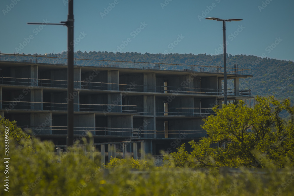 An abandoned construction site of a commercial building is waiting between the trees. Empty construction site, good for failed plans in construction photo An abandoned construction site of a commercial building is waiting between the trees. Empty construction site, good for failed plans in construction photo