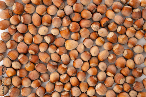Hazelnuts lit by direct morning sun on display at grocery store. Full frame of box full of nuts  horizontal macro close-up.