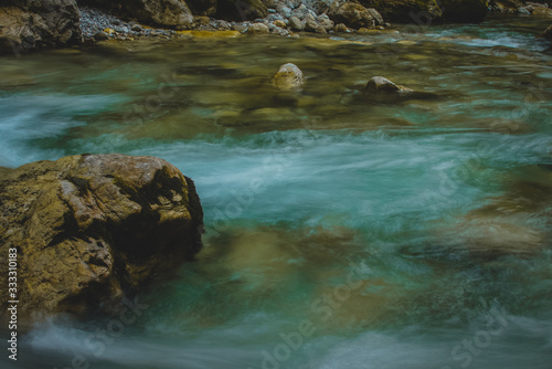 A beautiful green or turquoise river in Tolmin  Slovenia. Long exposure photo of water flowing over narrow rocks.