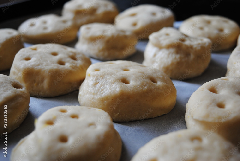 Mladenci - Traditional Serbian Homemade Fresh Dough Buns on a Baking Parchment Paper, ready to bake. Close up view.