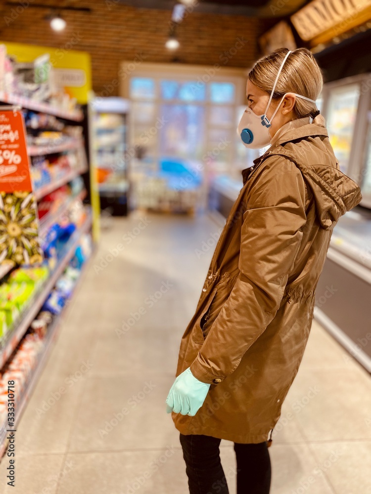 girl in a protective mask and gloves against coronavirus in a supermarket.  beautiful young woman.  grocery store.  Russian girl. Covid-2019.