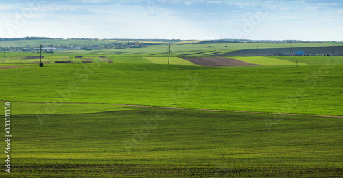 big panorama of of geometric patchwork of gardens, agricultural lands, farmland in springtime
