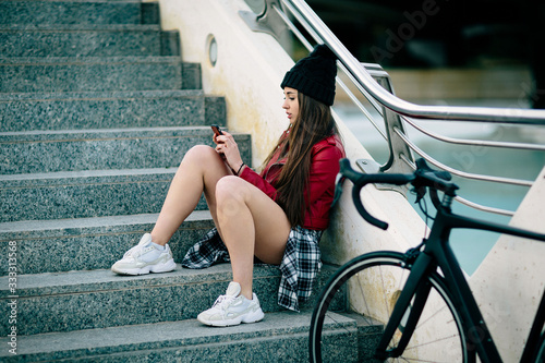 problem teenager sitting consulting his phone, travels with bicycle