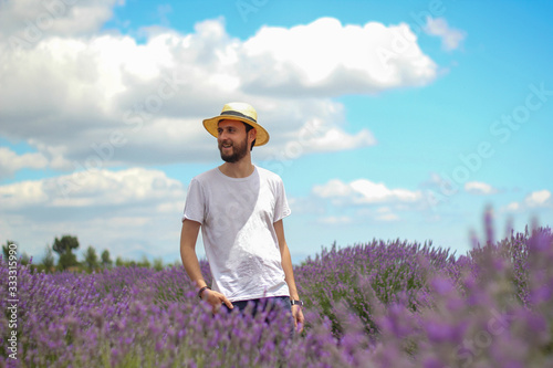 Young man walking through a lavender field at sunset