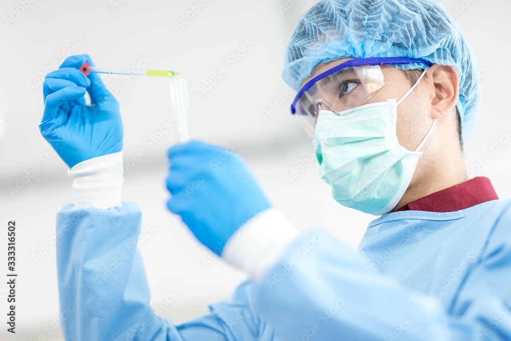 Asian scientists wear protective clothing while doing medical research in a science lab. Asian scientists wear protective clothing while doing medical research in a science lab.