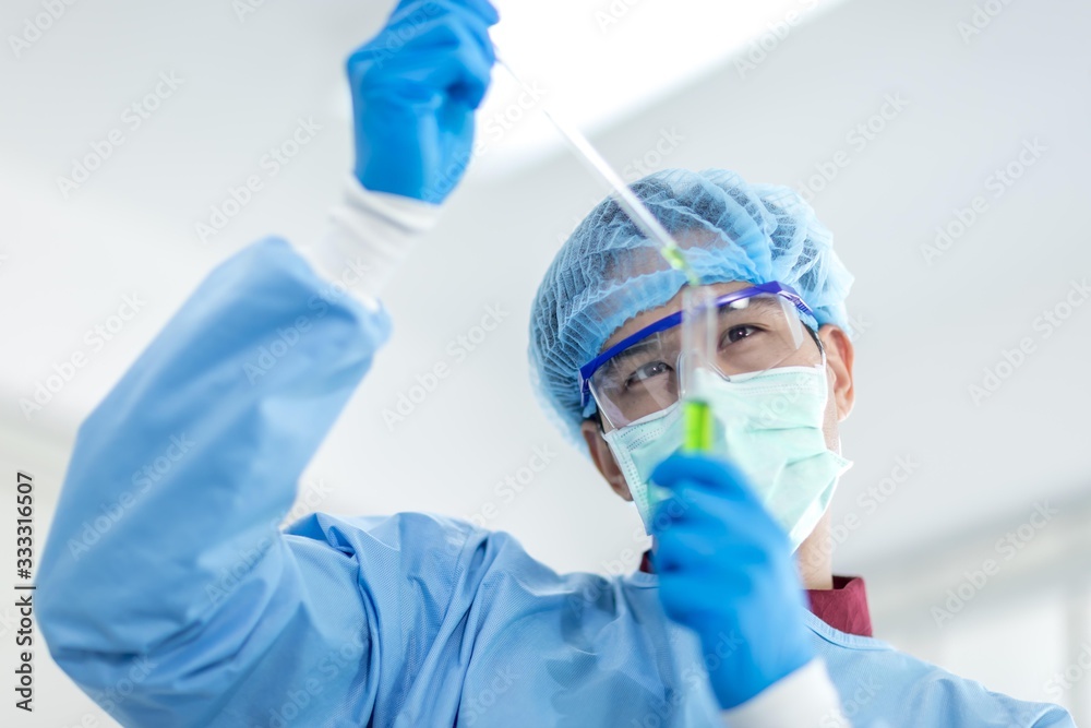 Asian scientists wear protective clothing while doing medical research in a science lab. Concepts, laboratory research on the antiviral drug Covid 19