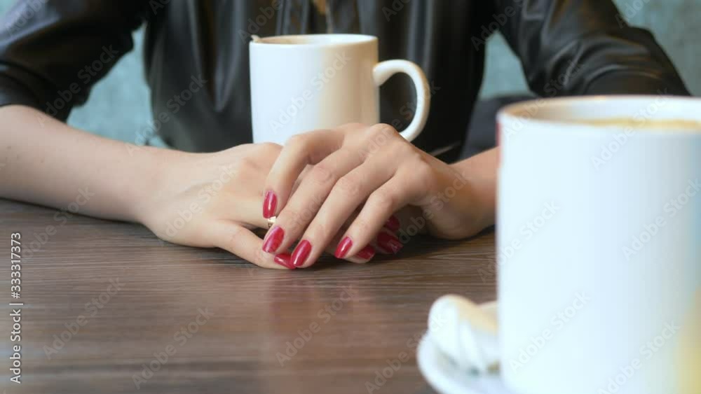 closeup. the woman takes off her wedding ring sitting in a cafe closeup. the woman takes off her wedding ring sitting in a cafe