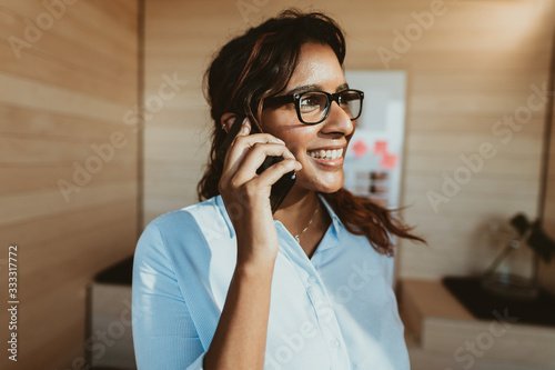 Woman in office talking on phone and smiling