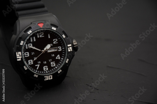 Modern wrist watch on black background.