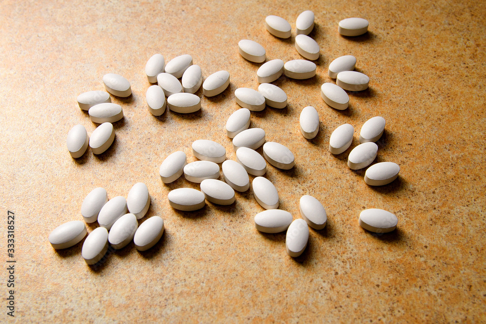vitamin D pills lie chaotically against a sand countertop vitamin D pills lie chaotically against a sand countertop