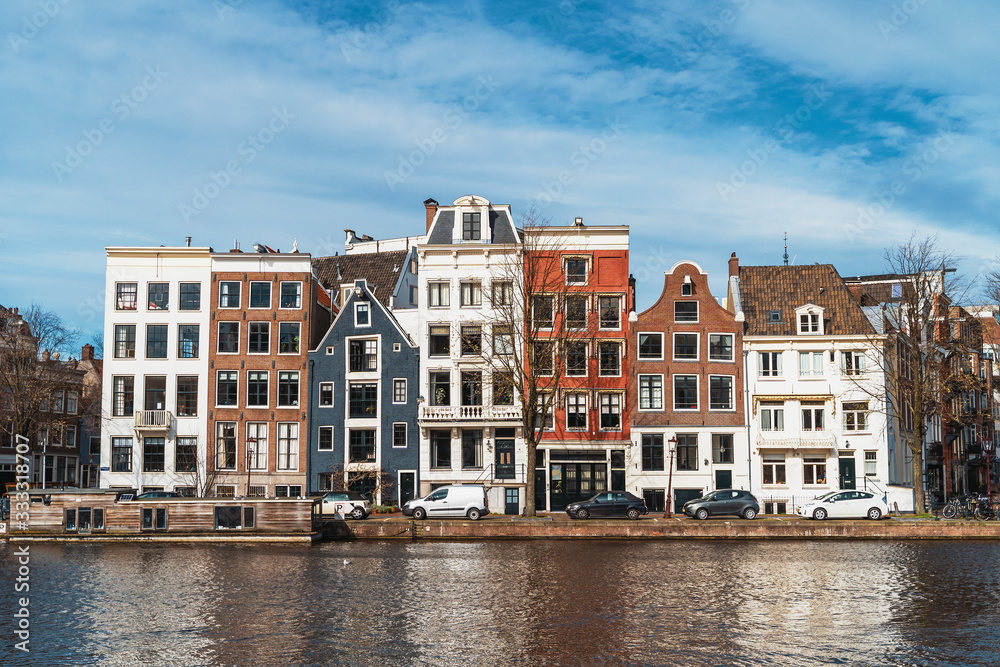 Typical famous dancing houses in Amsterdam landscape in warm spring sunny day, Netherlands.