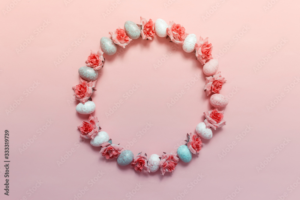 Creative decor wreath arranged in circle with Easter eggs and pink roses. Photo on pink background and copy blank space in the center.