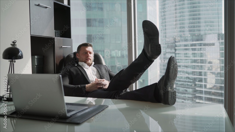 A man in a white shirt has put his feet on the desk. A man in a white shirt has put his feet on the desk.