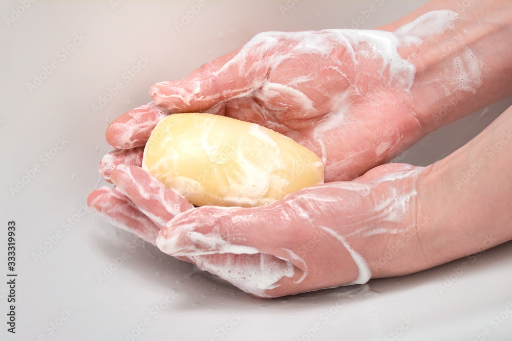 Washing hands sanitizing with soap bar. Hands with soapy foam on white background. Washing hands sanitizing with soap bar. Hands with soapy foam on white background.
