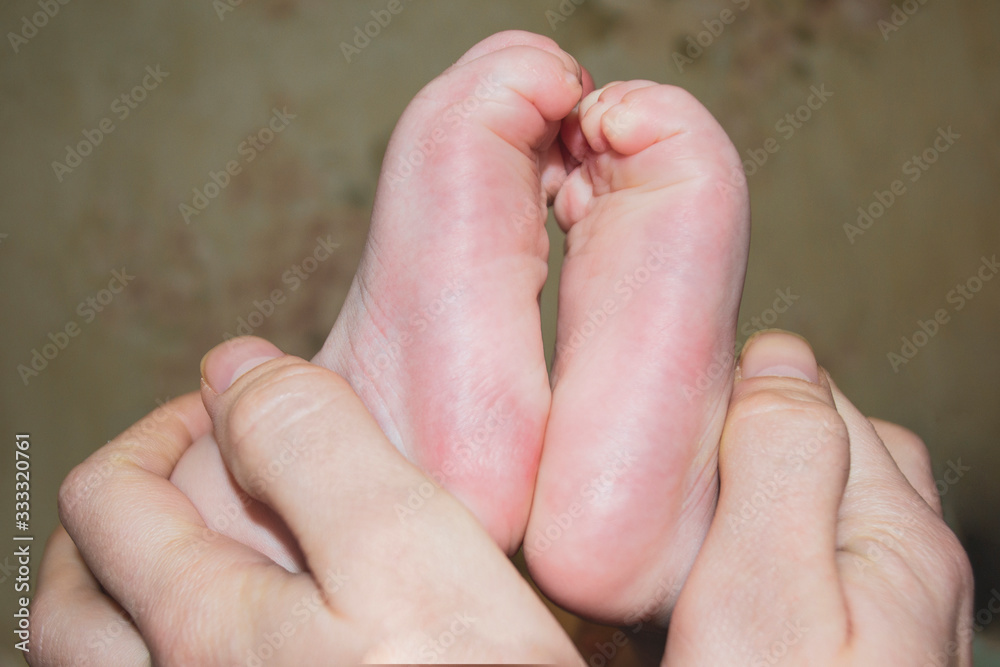 baby's legs in the hands of the mother, family happiness