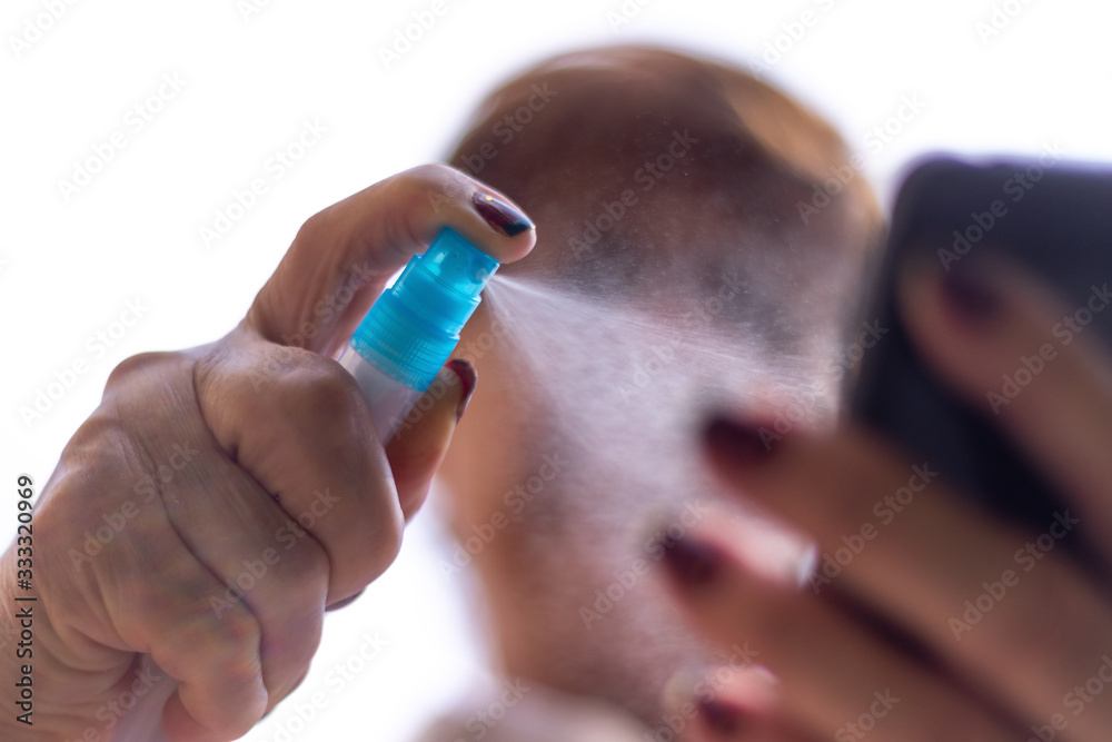 Fototapeta premium Alcohol spray to disinfect a mobile phone 