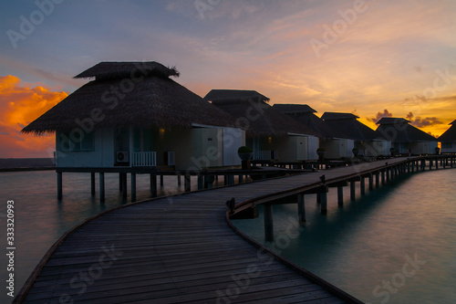Sunset on tropical island, water villas resort
