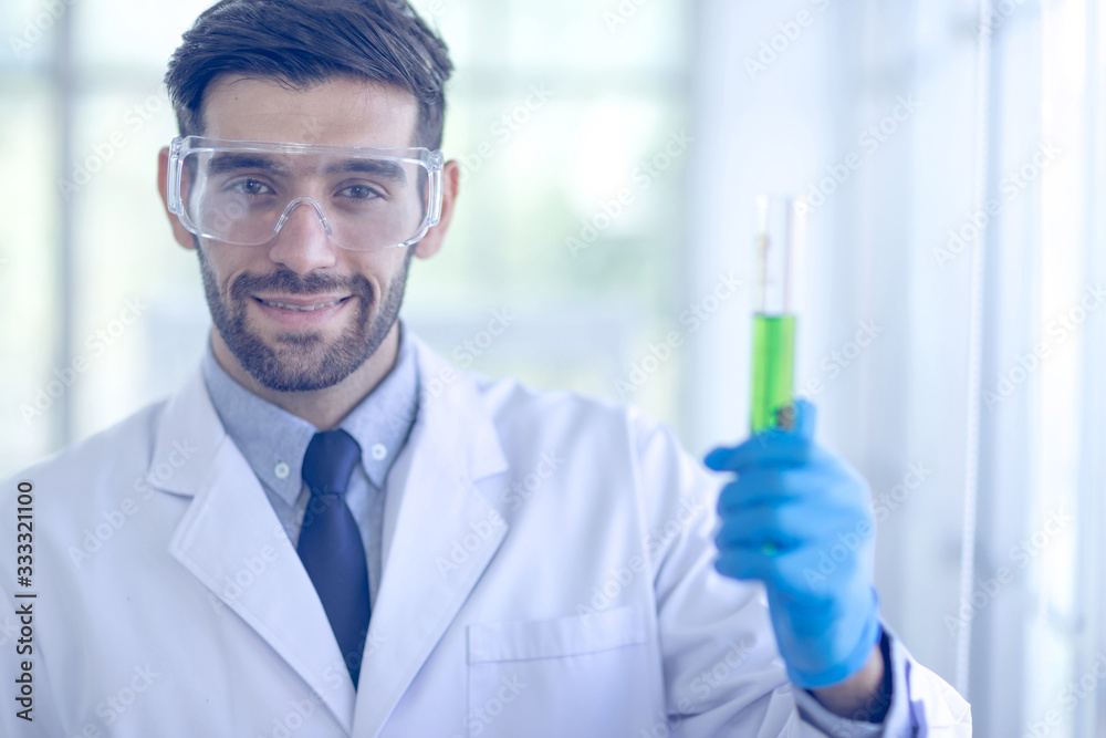 A male scientist wears a white coat and is researching chemicals in the laboratory. Concept, The scientists wear white protective clothing is experimenting with drug anti- Coronavirus A male scientist wears a white coat and is researching chemicals in the laboratory. Concept, The scientists wear white protective clothing is experimenting with drug anti- Coronavirus