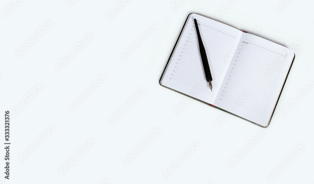 Fountain pen and black open diary on a white background Fountain pen and black open diary on a white background