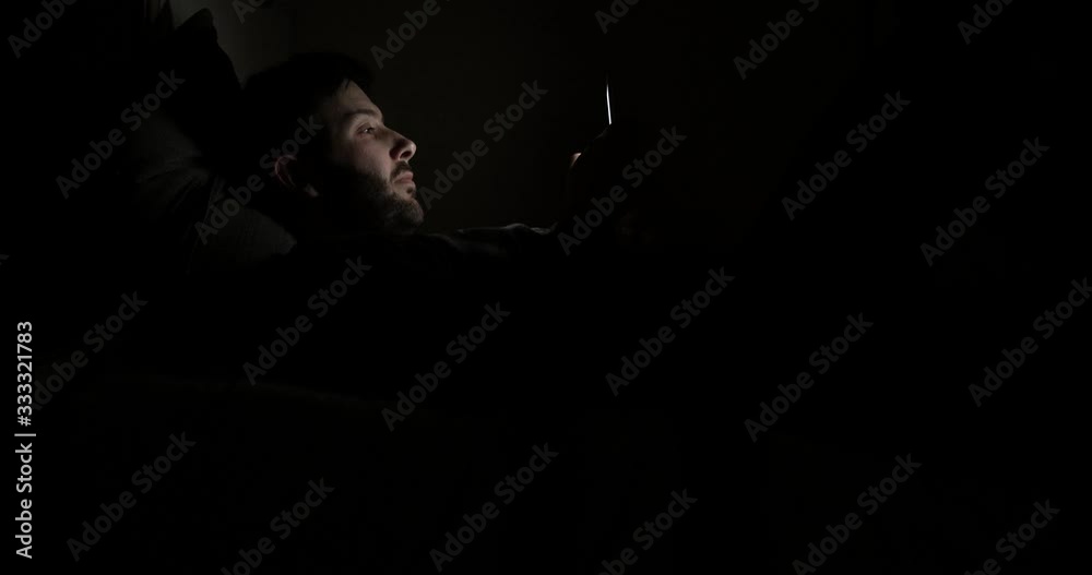 Man using the smartphone before going to sleep Man using the smartphone before going to sleep