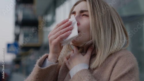 Sad young woman sneezing coughs feel sick at outdoor fever cold allergy disease female nose sneeze lady runny tissue air pollution adult illness district coronavirus pandemic pneumonia covid19