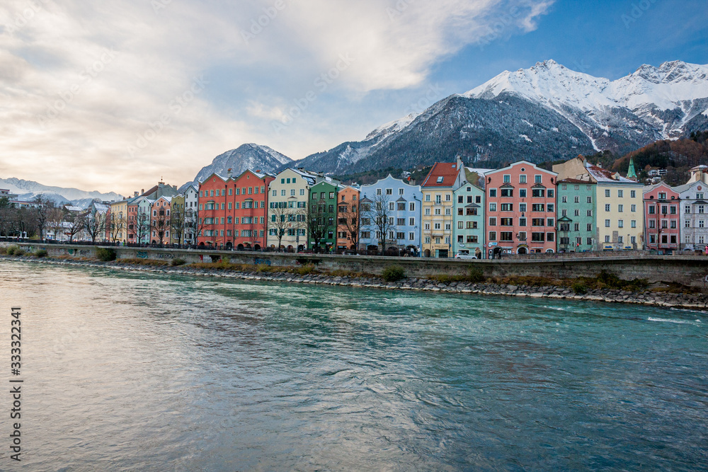 Colorful houses of the city of Innsbruck with river and snowy mountains
