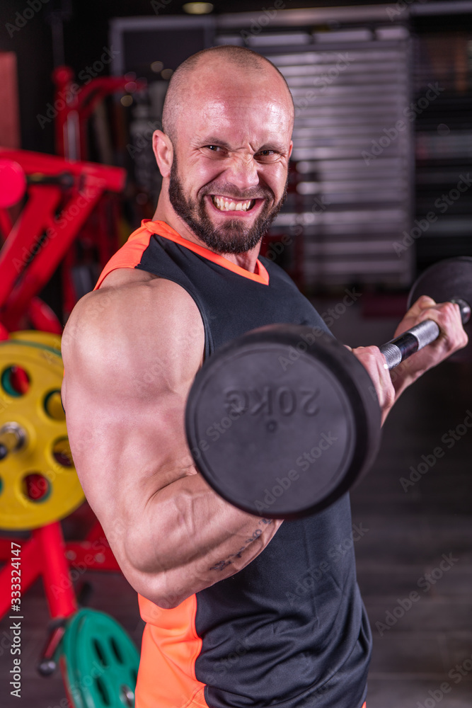 Close up of powerful muscular man doing biceps exercise with barbell at the gym Close up of powerful muscular man doing biceps exercise with barbell at the gym