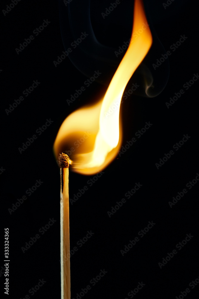 A burning safety match with yellow and blue fire A burning safety match with yellow and blue fire