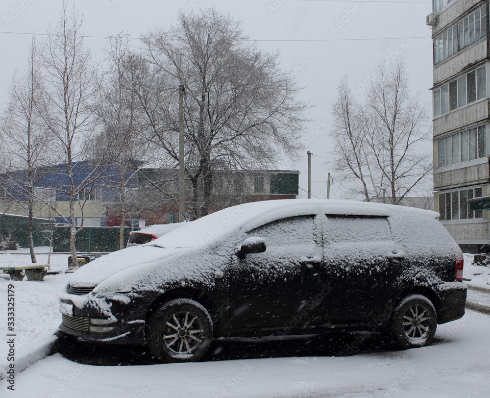 black vehicle under spring snowfall